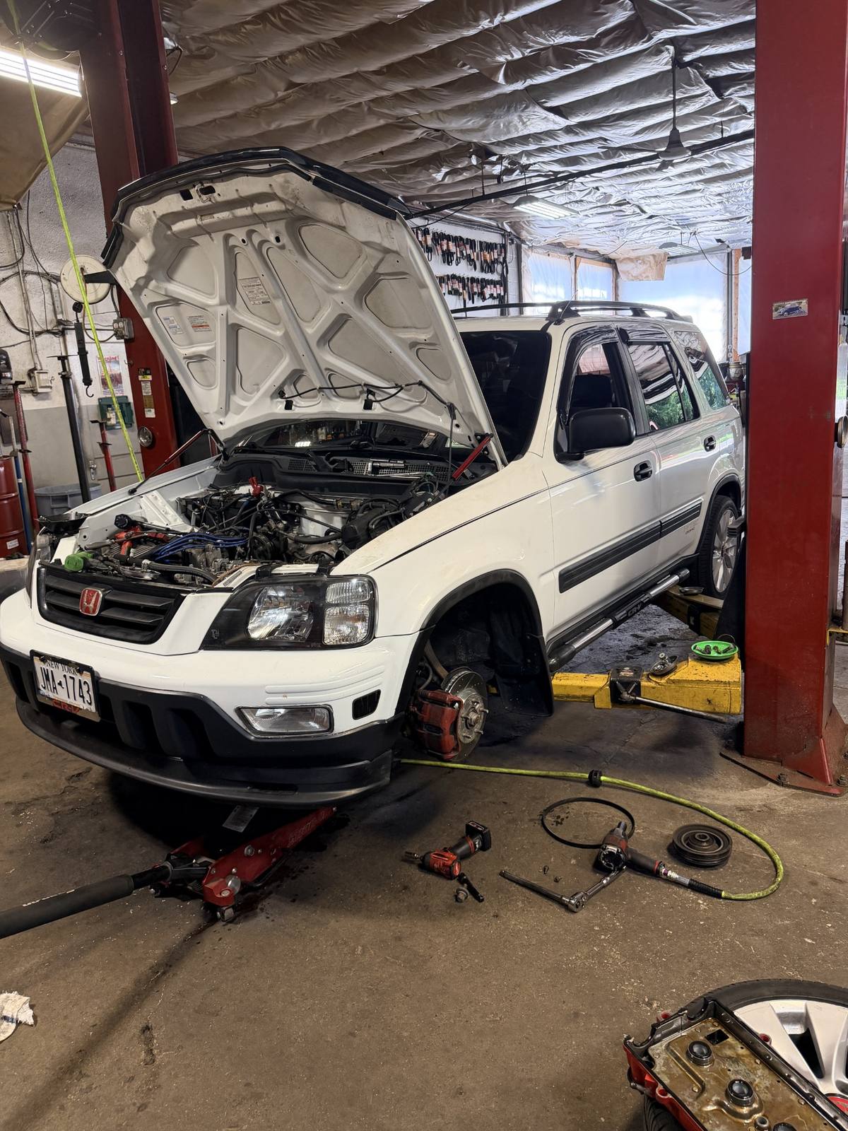 Brake and mechanical repair on a vehicle lift inside Allen's Import Service in Highland Falls, NY
